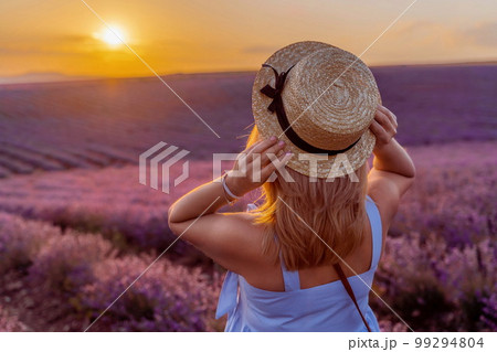 Woman lavender field sunset. Romantic woman walks through the la 99294804