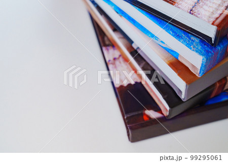 photobooks stacked on top of each other on a white table. 99295061