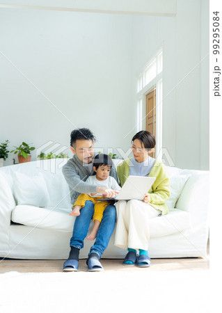 ソファでパソコンを見るファミリー　 99295084