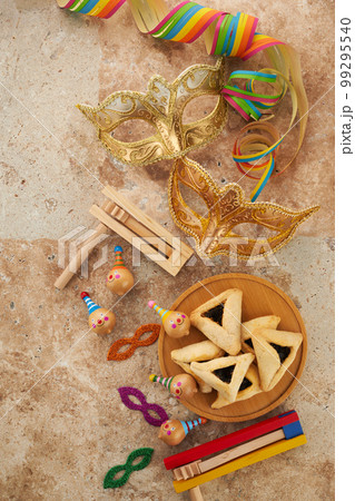 Purim celebration concept. Jewish carnival background. hamantaschen or hamans ears cookies, carnival mask and noisemaker 99295540