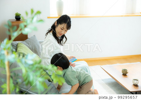 リビングでスマホを見る親子 99295657