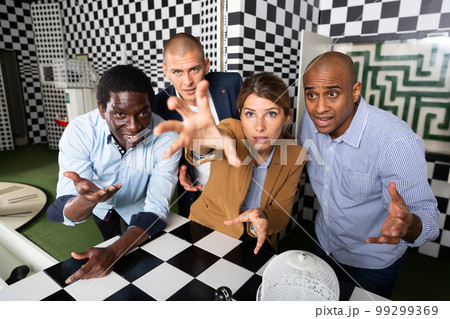 Quest game - group of adults reach for the key to complete the next level of game 99299369