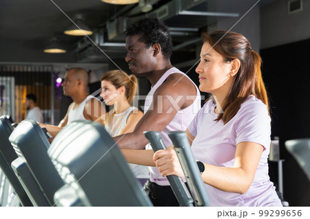 People having running elliptical trainer class in club People having running elliptical trainer class in club 99299656