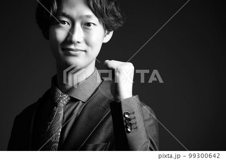 小さくガッツポーズをしながら視線を向ける若いビジネスパーソン モノクロイメージ 小さくガッツポーズをしながら視線を向ける若いビジネスパーソン モノクロイメージ 99300642
