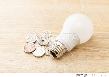 テーブルに置かれたLED電球と小銭 テーブルに置かれたLED電球と小銭 99300795