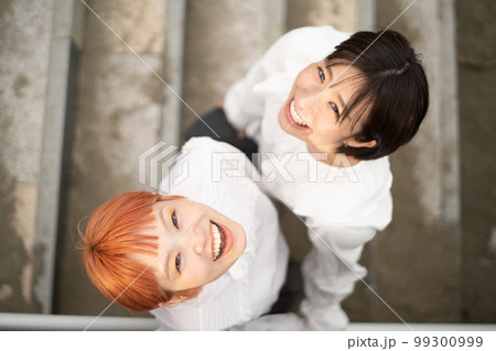 見上げて笑う若い女性二人のポートレート 99300999