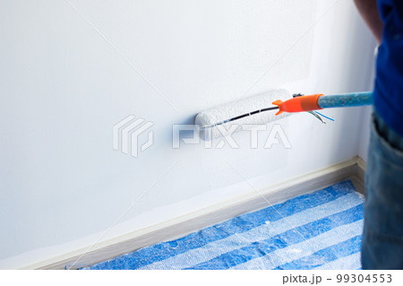 painter man with paint roller brush painting the wall. Renovation, maintenance and development of home or apartment 99304553