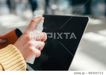 close up. the woman spraying the spray on the laptop screen 99304715
