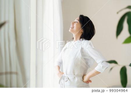 窓辺で日光を浴びるミドル女性 99304964