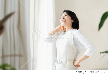 窓辺で日光を浴びるミドル女性 99304965