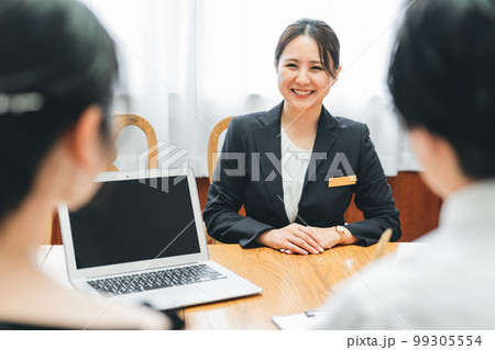 コンシェルジュ・ホテリエ・ウェディングプランナーと打ち合わせ・契約する男女（結婚相談所） 99305554