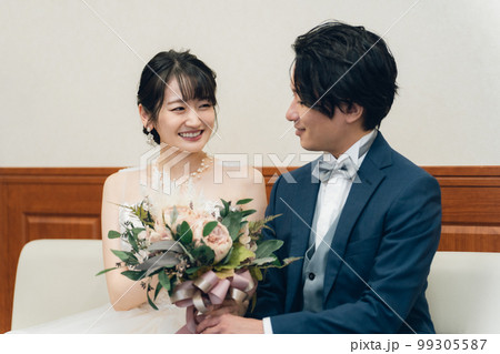 結婚式場のブライズルーム・控室で花束・ブーケを持つ新郎新婦の男女(ドレス試着・衣装合わせ) 99305587