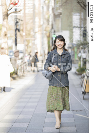 歩道を歩く笑顔のアラフィフの女性 99305815