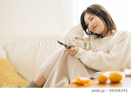 部屋でくつろぐ主婦・テレビを見る女性 99306242