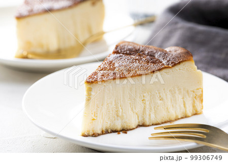 明るいテーブルにバスクチーズケーキと金色のフォーク 99306749