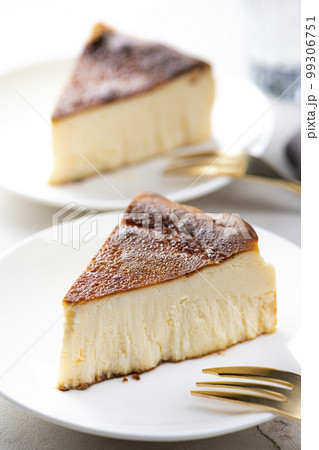 明るいテーブルにバスクチーズケーキと金色のフォーク 99306751