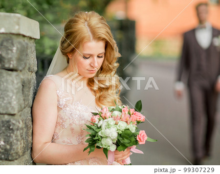 bride with a wedding bouquet standing on a city street. bride with a wedding bouquet standing on a city street. 99307229