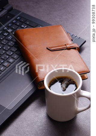 ノートパソコン、システム手帳、コーヒーでデスクワーク ノートパソコン、システム手帳、コーヒーでデスクワーク 99308738