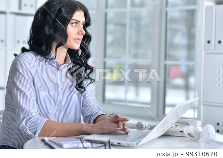 Portrait of a lyoung woman with phone working in office 99310670