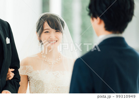 結婚式場で新郎の待つチャペルまでバージンロードを歩く新婦・花嫁の女性 99310949