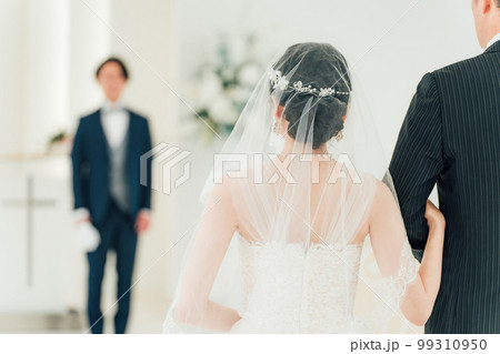 結婚式場・チャペルでバージンロードを歩く新婦を待つ新郎・花婿の男性 99310950