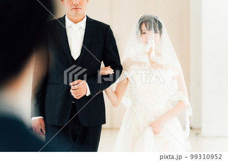 結婚式場で新郎の待つチャペルまでバージンロードを歩く新婦・花嫁の女性 99310952