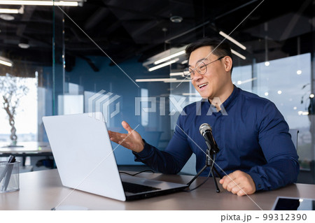 Successful Asian businessman mentor recording audio podcast, man in office using professional microphone for online radio and audio book recording 99312390