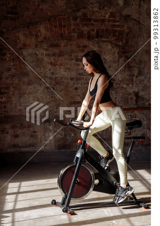 Fitness woman on a bicycle is engaged in spinning in the gym. 99313862