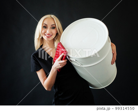 Beautiful blonde woman wth make up and red clutch and white barrel on black background 99314550