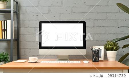 Comfortable workplace with computer and supplies against brick wall. Blank screen for graphic display montage Comfortable workplace with computer and supplies against brick wall. Blank screen for graphic display montage 99314729