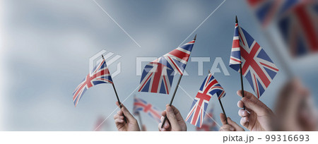 A group of people holding small flags of the United Kingdom in their hands 99316693