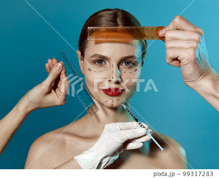 Making beauty, modifying face to make non-surgical or surgical correction, plastic surgery. correction of asymmetry. Young woman, female patient isolated on blue studio background. Lifting concept 99317283