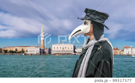 Famous Plague Doctor Mask at a traditional carnival festival with panorama of Venice in Italy 99317377