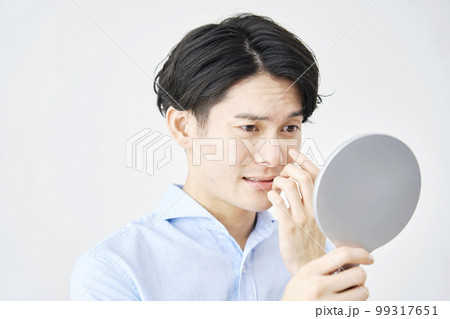 目元を鏡を見る男性　白背景 99317651