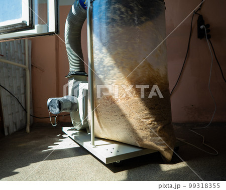 Vacuuming sawdust while sawing wood. Chip blower in furniture production.  99318355