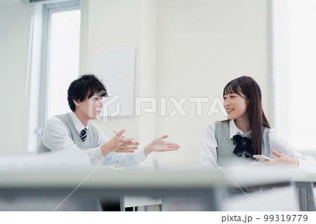 同級生と教室で仲良く話す高校生 99319779