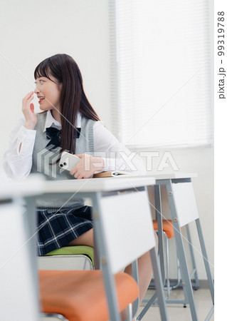 同級生と教室で仲良く話す高校生 99319788