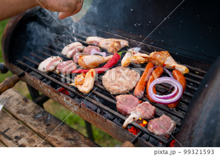 Assorted delicious grilled meat with vegetables over the coals on barbecue Assorted delicious grilled meat with vegetables over the coals on barbecue 99321593