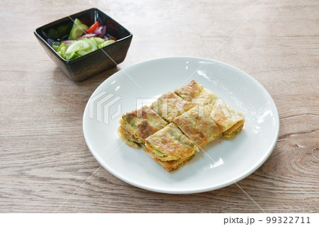 fried Murtabak roti stuffed beef meat on plate dipping sweet pickled cucumber sauce 99322711