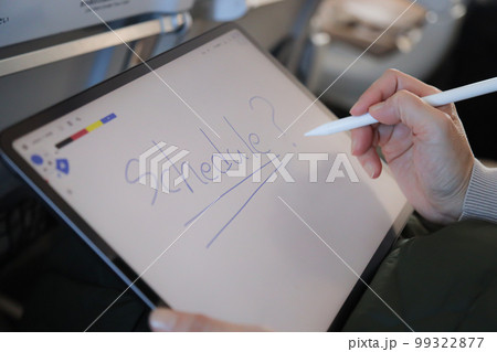 飛行機の機内でタブレットを操作する人　メモアプリに字を書く　 99322877
