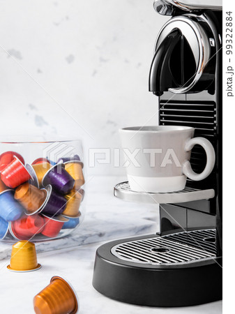 Preparation of fresh morning coffee from espresso machine with pods on white kitchen 99322884