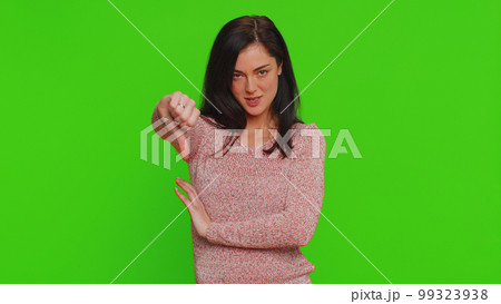 Upset young woman girl in sweater showing thumbs down sign gesture disapproval dissatisfied dislike Upset young woman girl in sweater showing thumbs down sign gesture disapproval dissatisfied dislike 99323938