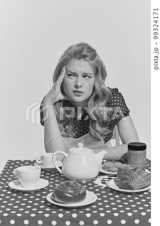 Retro blond. Monochrome portrait of young beautifl girl sitting at the table. Concept of beauty, retro style, fashion, elegance, 60s, 70s, family. 99324171