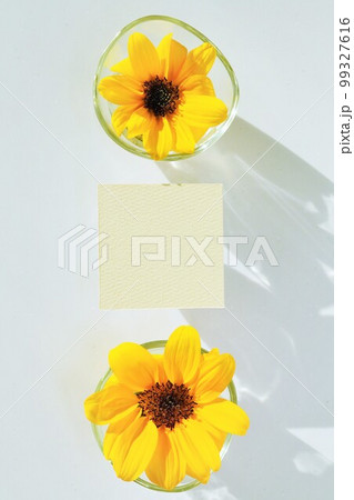 ガラスの器に入った黄色い夏らしいひまわりの花を飾ったオシャレなタイトルスペースのモックアップ ガラスの器に入った黄色い夏らしいひまわりの花を飾ったオシャレなタイトルスペースのモックアップ 99327616