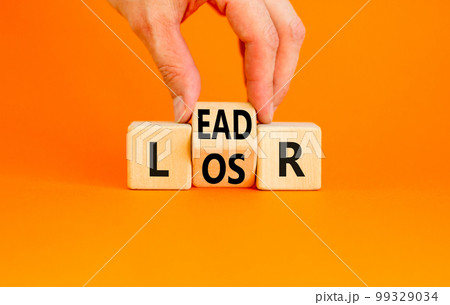 Leader or loser symbol. Concept word Leader Loser on wooden cubes. Beautiful orange table orange background. Businessman hand. Business and leader or loser concept. Copy space. 99329034