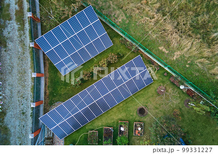 Solar photovoltaic panels mounted on stand-alone frame on backyard ground for generating of clean ecological electric energy. Concept of autonomous house 99331227