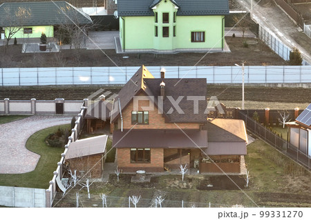 Residential houses with roof tops covered with metallic and ceramic shingles in rural suburban area Residential houses with roof tops covered with metallic and ceramic shingles in rural suburban area 99331270