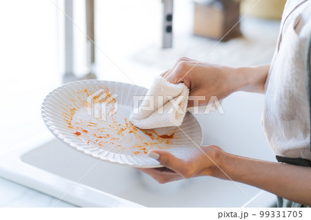食器の油汚れを拭き取る写真 99331705