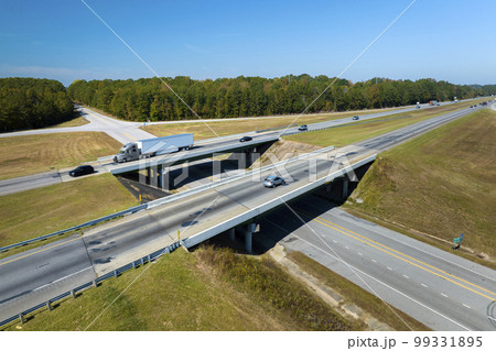 Elevated view of freeway exit junction over road lanes with fast moving traffic cars and trucks. Interstate transportation infrastructure in USA 99331895