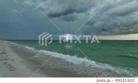 Dark weather front clouds forming on stormy sky during heavy rainfall season over sea water in summer evening 99331920